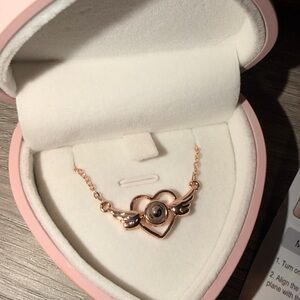 Elegant Heart Wing Necklace in Rose Gold, casts I LOVE YOU in diff languages.